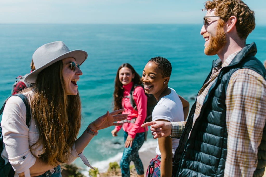 Group of people standing on a cliff overlooking the ocean